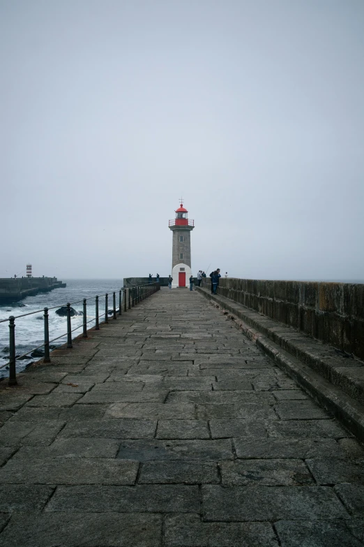 the lighthouse is built along the concrete walkway