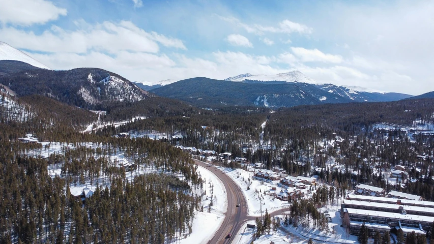 a snow covered landscape and forest in the mountains