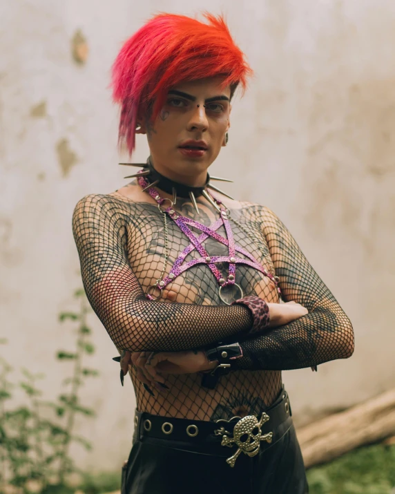 a young man with orange hair and fishnet tattoos