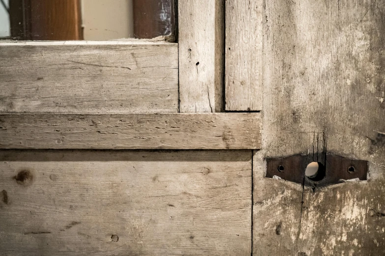 a door is painted white with a wooden frame and metal latch