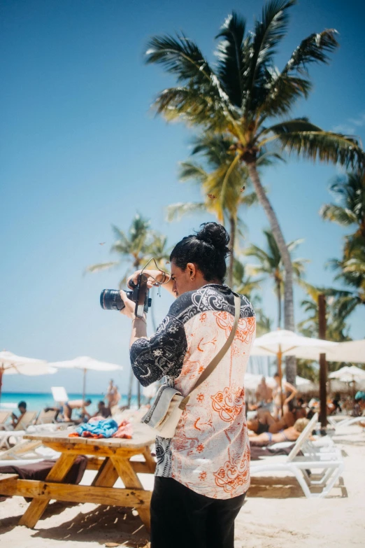 a man standing on the beach taking a po with his camera