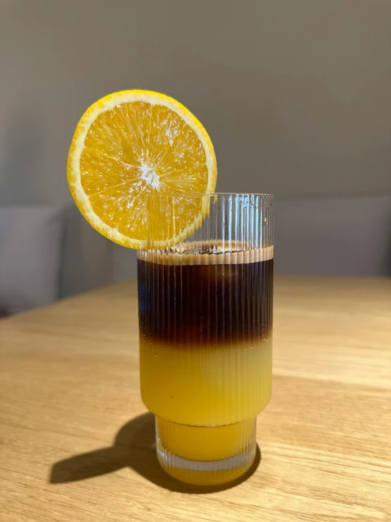 a glass with a drink sitting on top of a table