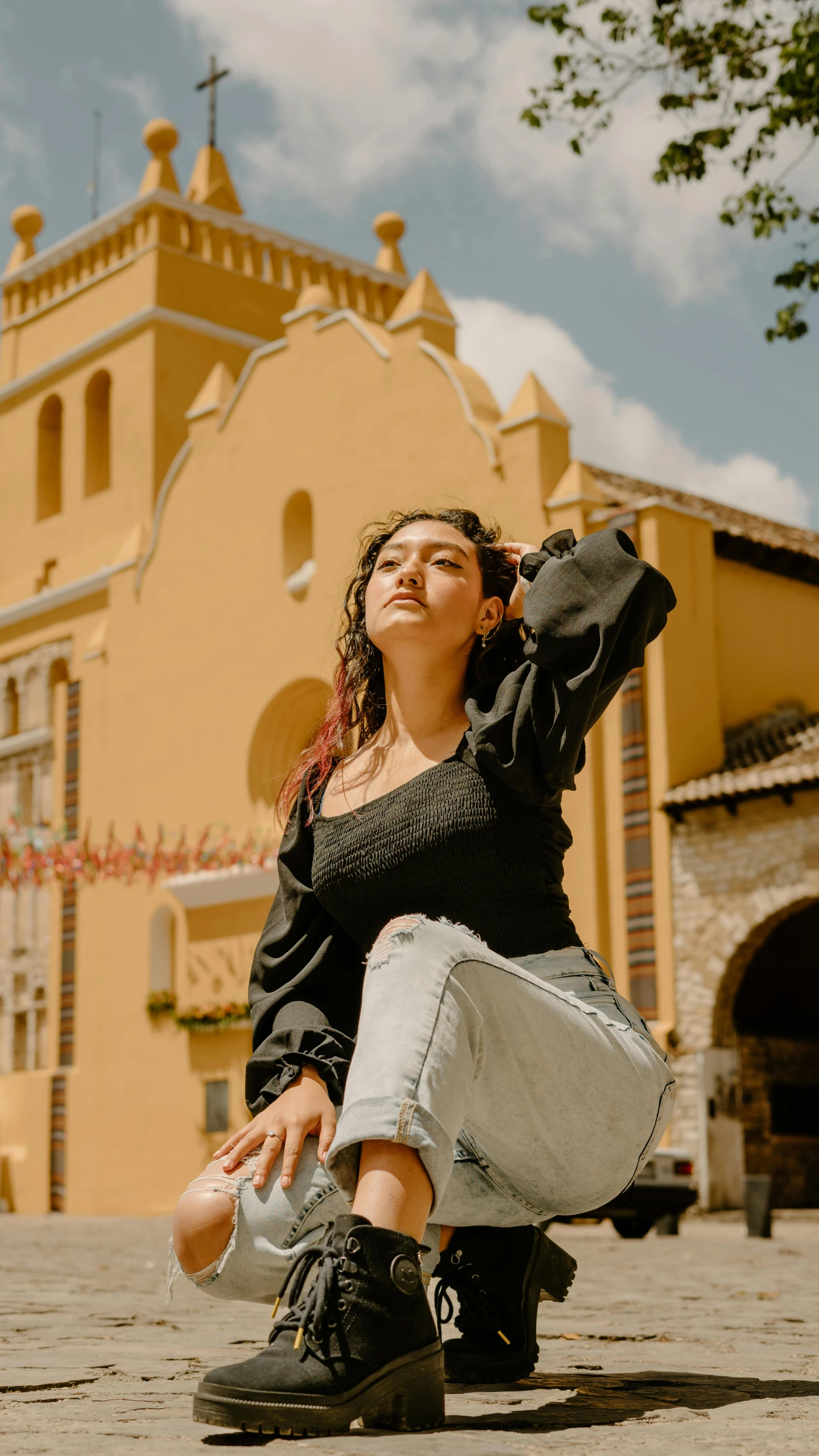 a woman sitting on the ground with a camera around her neck