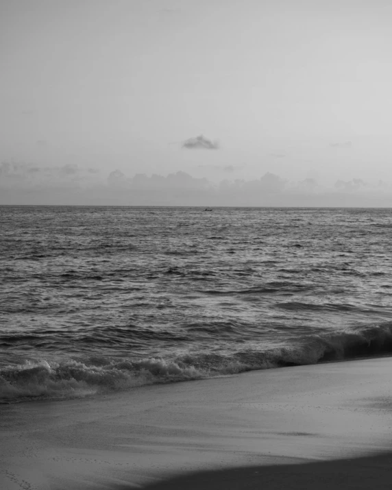 a woman walks along the shore line near an ocean