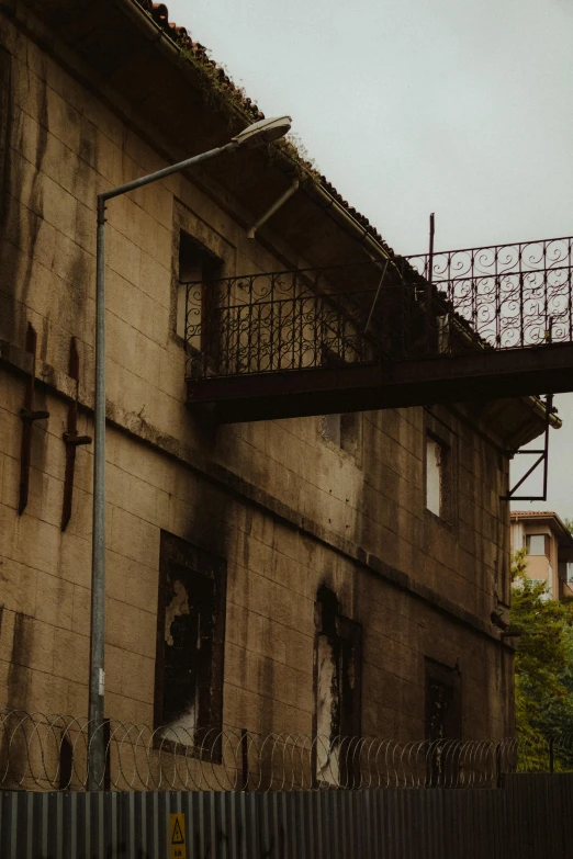 a building with a fence surrounding it and some buildings on it