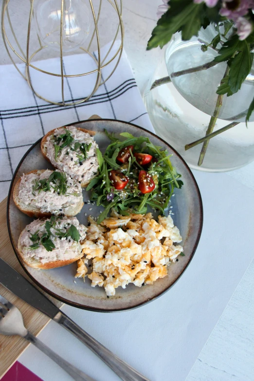 two loaves of bread with meat on a plate with fresh salad