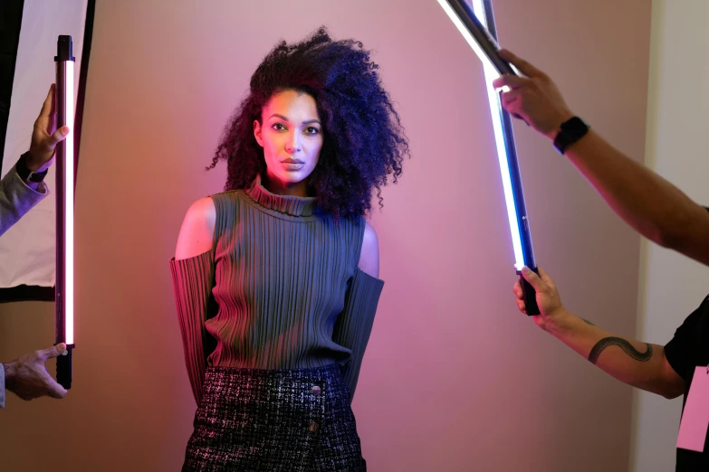 two women holding up lightsabens and some lights