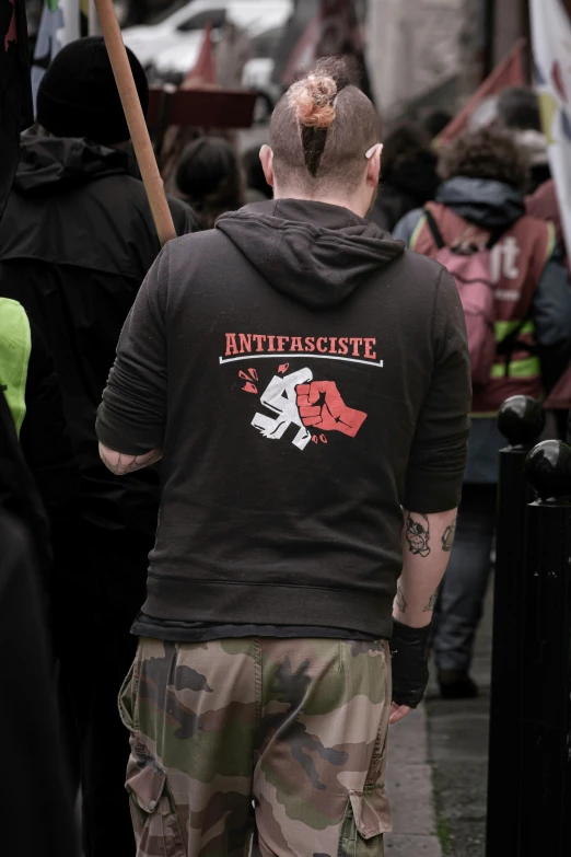 a man walking down a street while wearing camo shorts