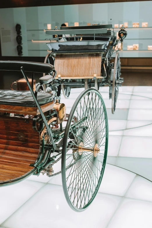 an old antique car with wheel spokes sits on the floor