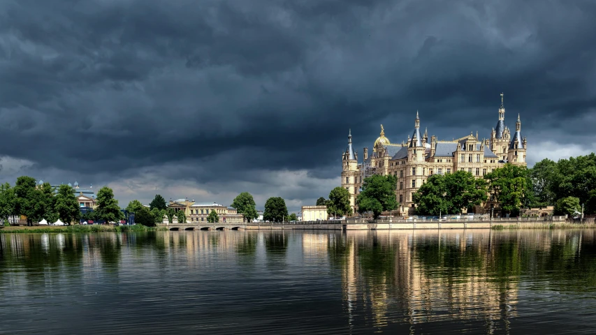 a lake with a castle in the background on a cloudy day