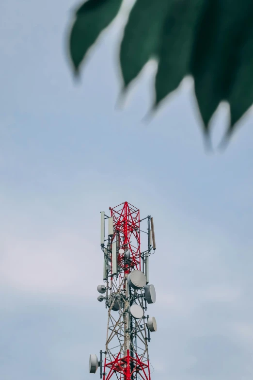 a red and white radio tower against a blue sky