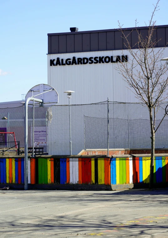 a brightly colored fence is in front of a tall building