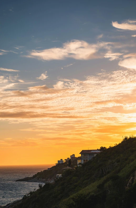 a sunset scene with a house on top of a hill