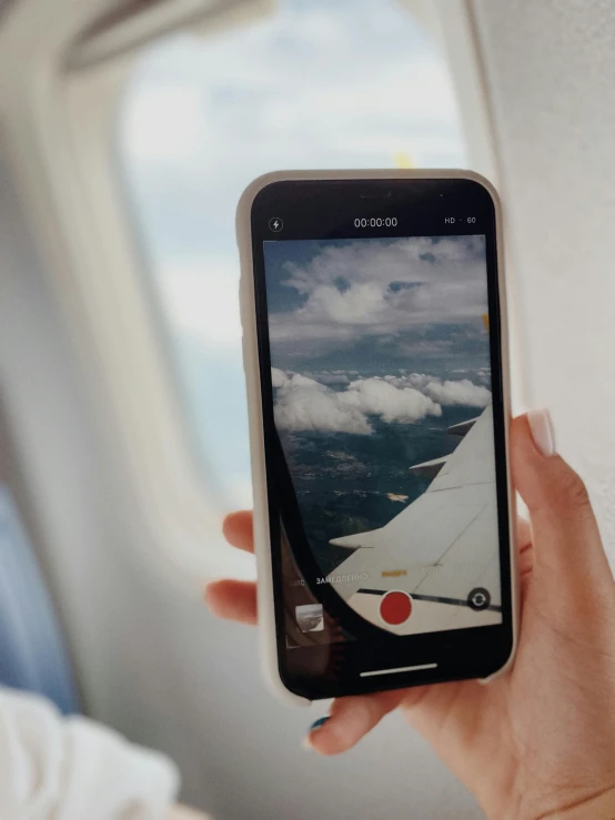 someone holding up an image of a plane that is on their phone