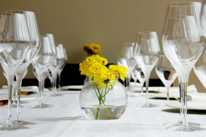 a vase filled with yellow flowers sitting on top of a white table