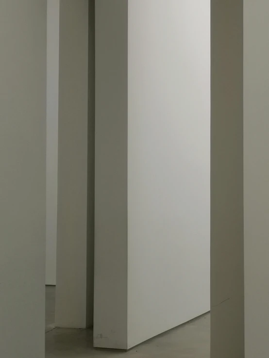 two tall white pillars sit in an empty room