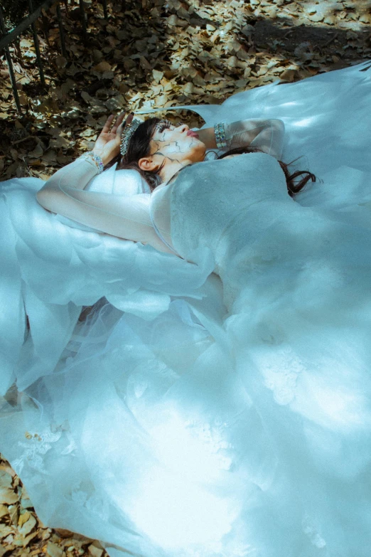 woman in white costume laying on the snow