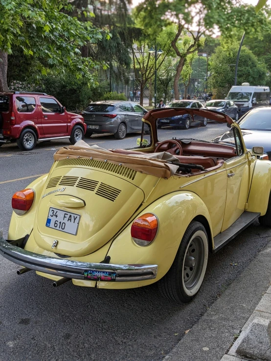 the yellow volkswagen is parked along the side of the road