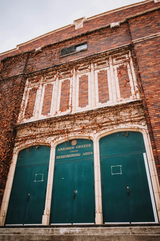 an old red brick building with a green door