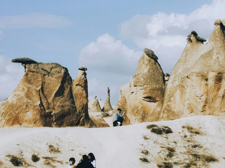 two people taking pictures of some very large rock formations