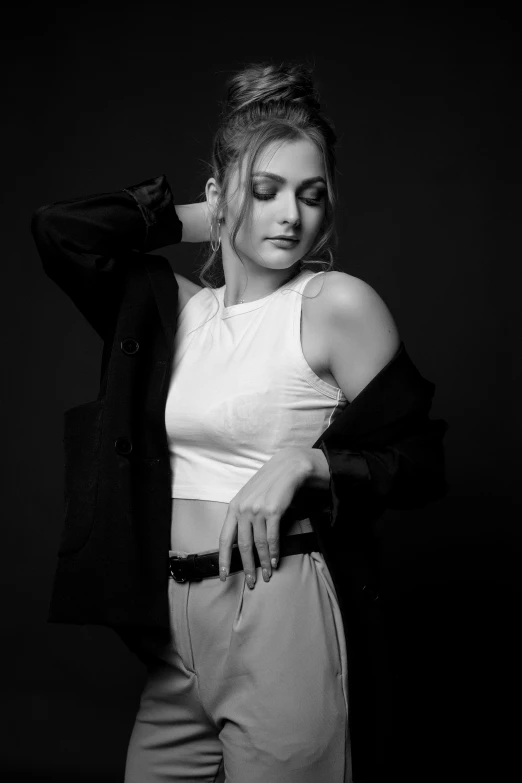 woman in studio poses leaning on jacket and holding her arms on one shoulder