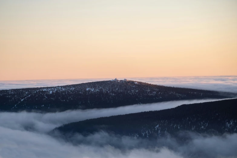 there are clouds hanging over the hills