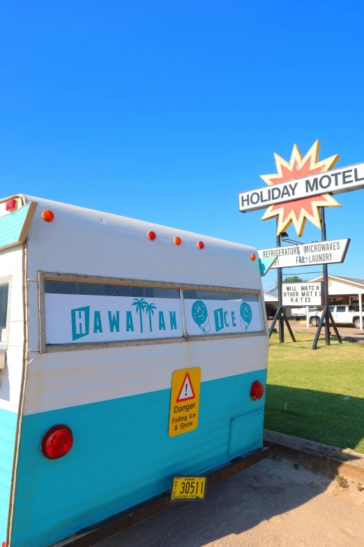 an old travel trailer parked in front of a motel