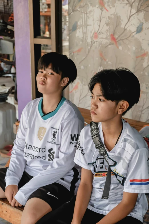 two boys sit and stare away from the camera