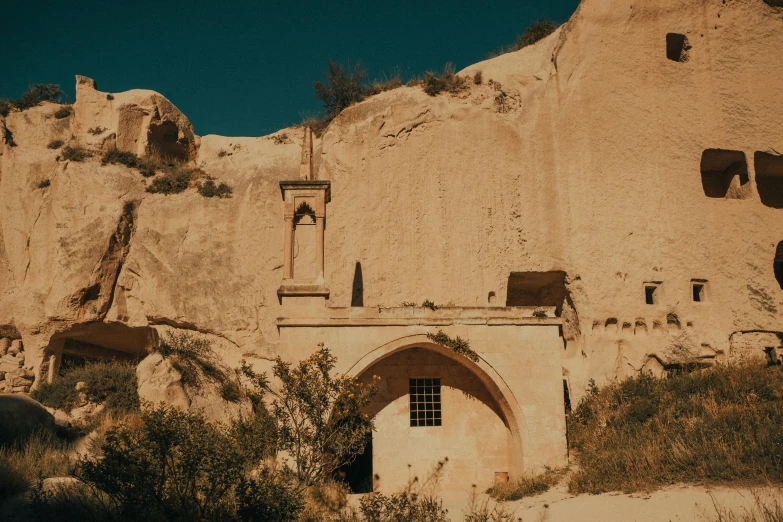 an adobe church near an outcropping of hills