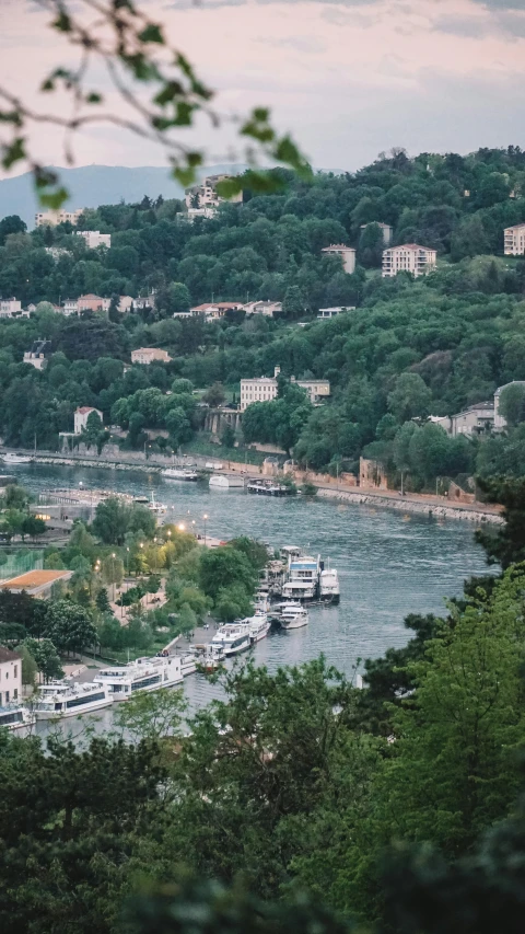 there is boats parked along the river next to the hill