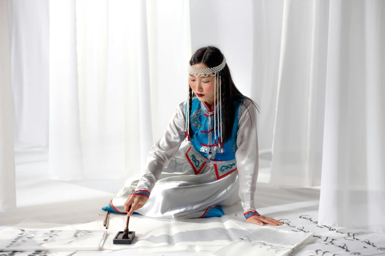 a woman sitting on the floor and writing on the sheet