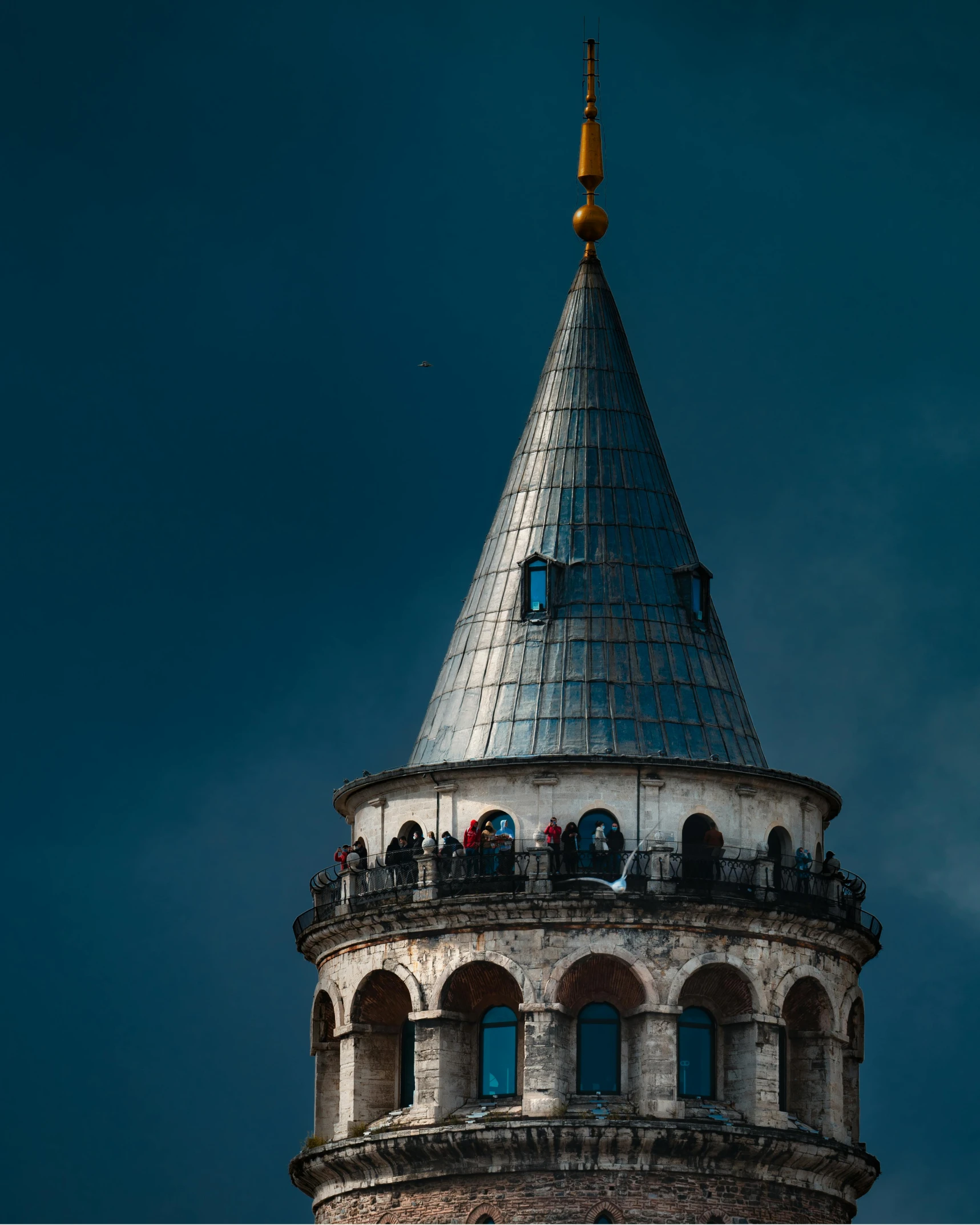 the building has two domes on top and some people sitting in windows on the windows sill