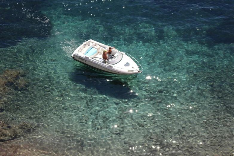 the small boat is sitting on the clear blue water