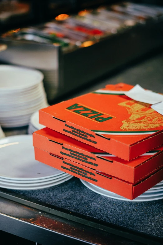 orange boxes sit on plates in a restaurant kitchen