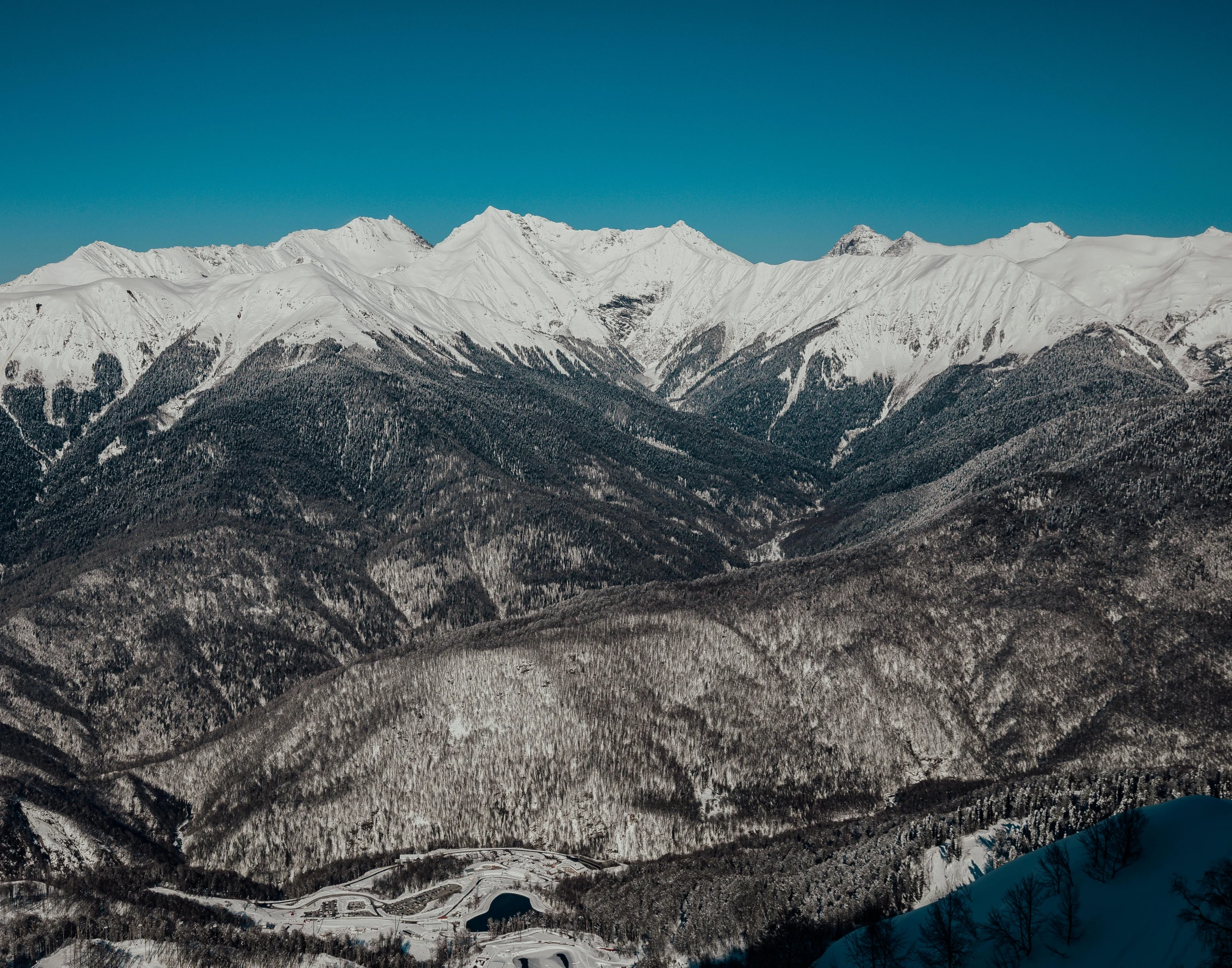 the mountains are covered in snow and clear blue skies