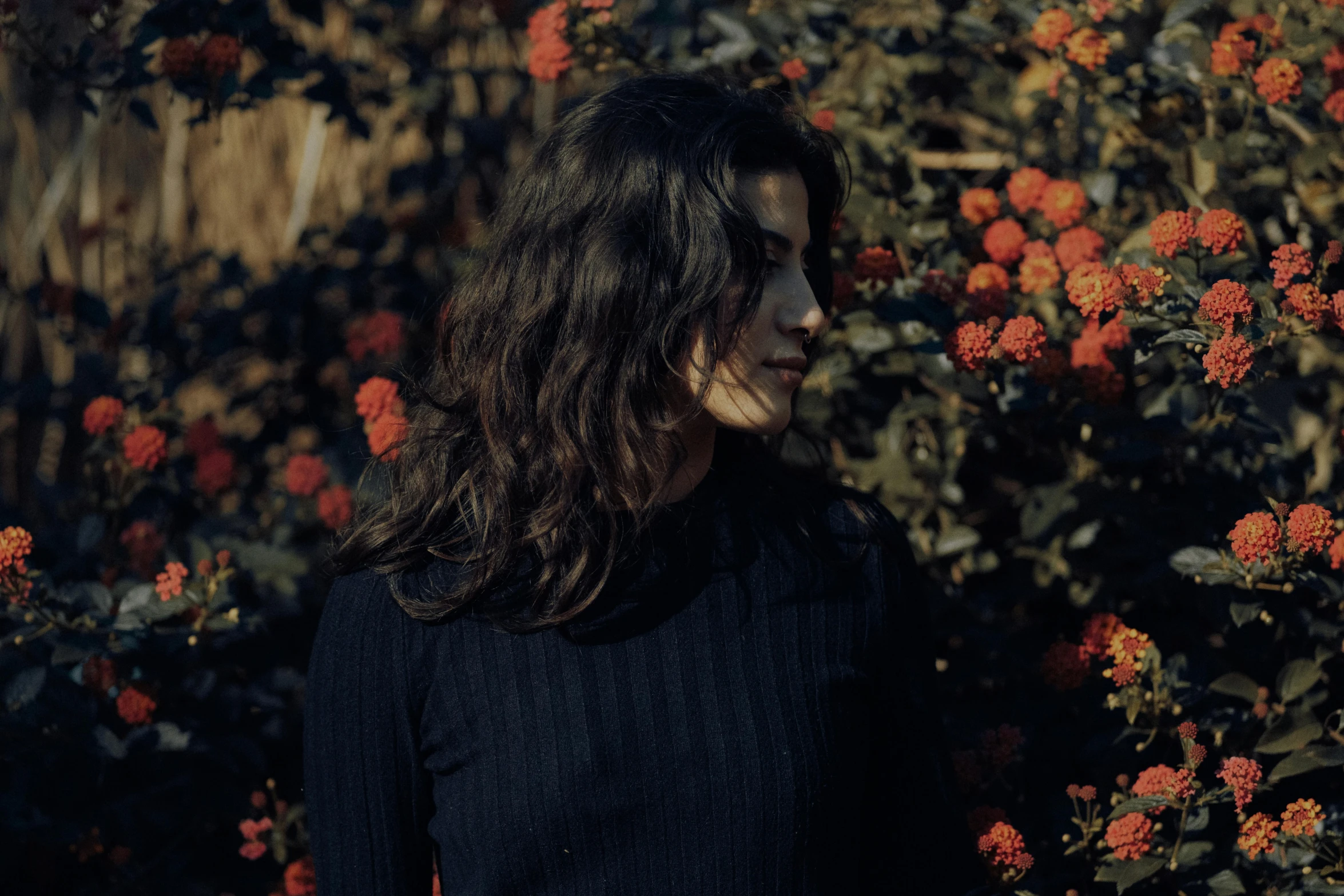 the woman is standing in front of many flowers