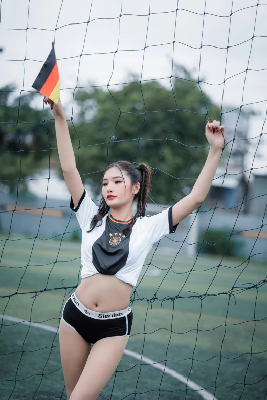 woman playing soccer in the net and holding a small flag
