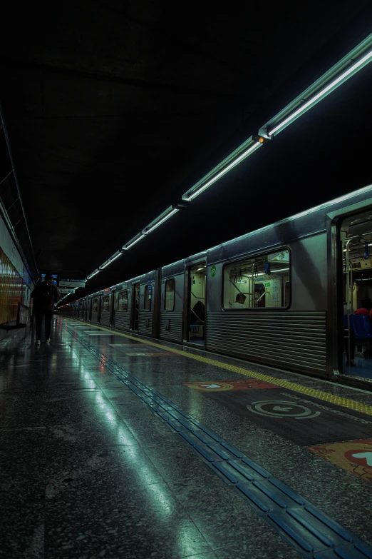 people walking in the dark near a subway train