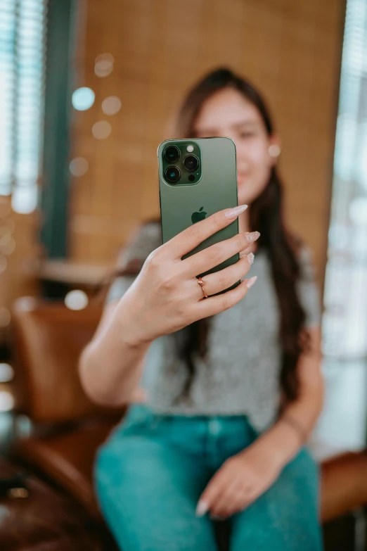 a girl is holding up her green phone