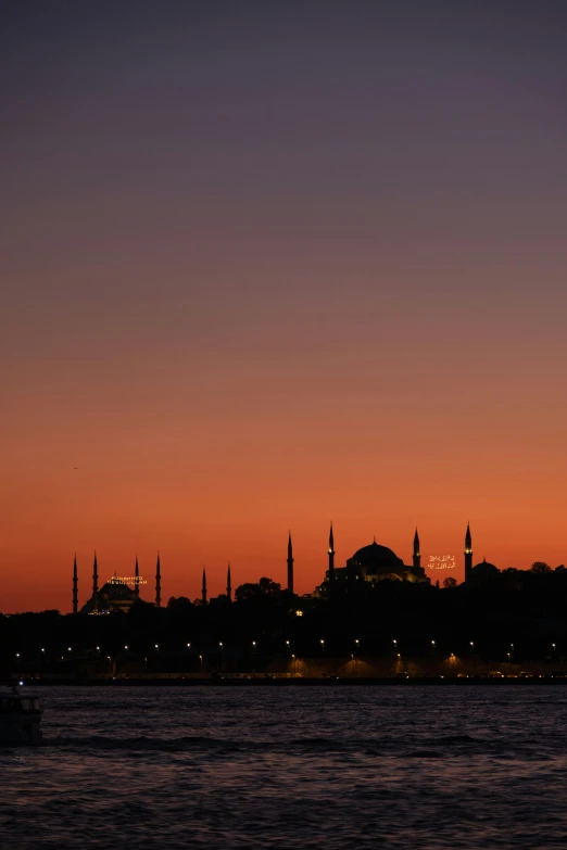 a city in the distance is glowing at night