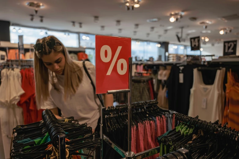 woman browses through clothing at a market in a mall