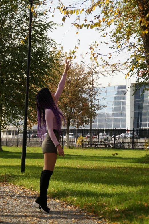 a woman in high heels and socks is reaching up for leaves