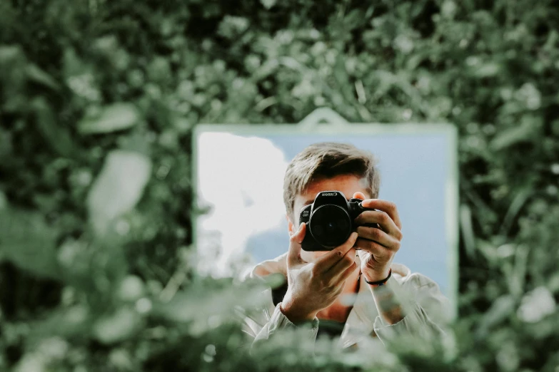 a man taking a po of himself while in front of trees