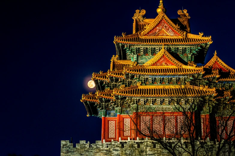 the tower of a chinese style temple lit up at night