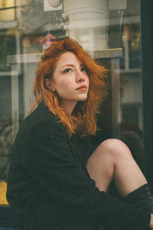 a woman with bright red hair sitting down