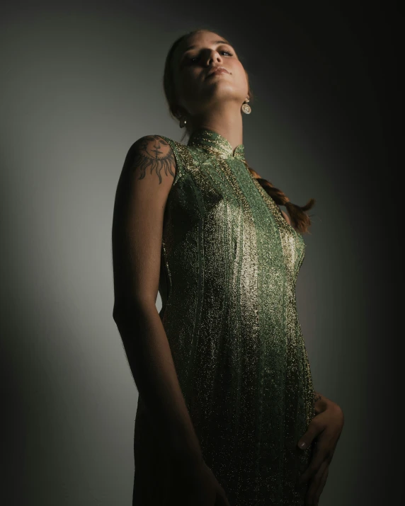 a woman with a green dress and tattoos on