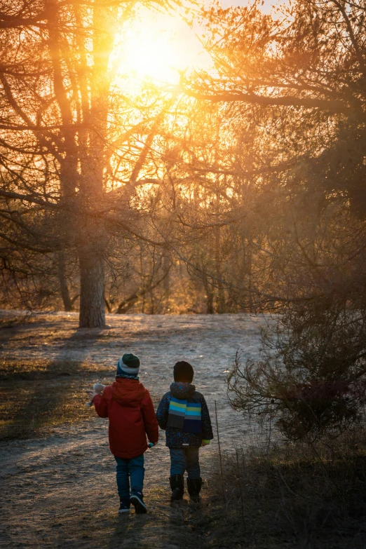 two s walking down a road through some trees