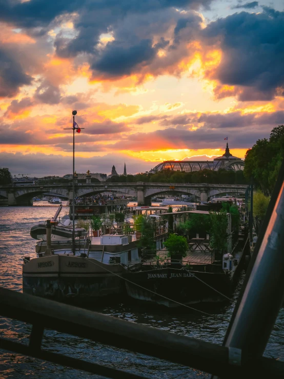 two boats are moored in the water at sunset