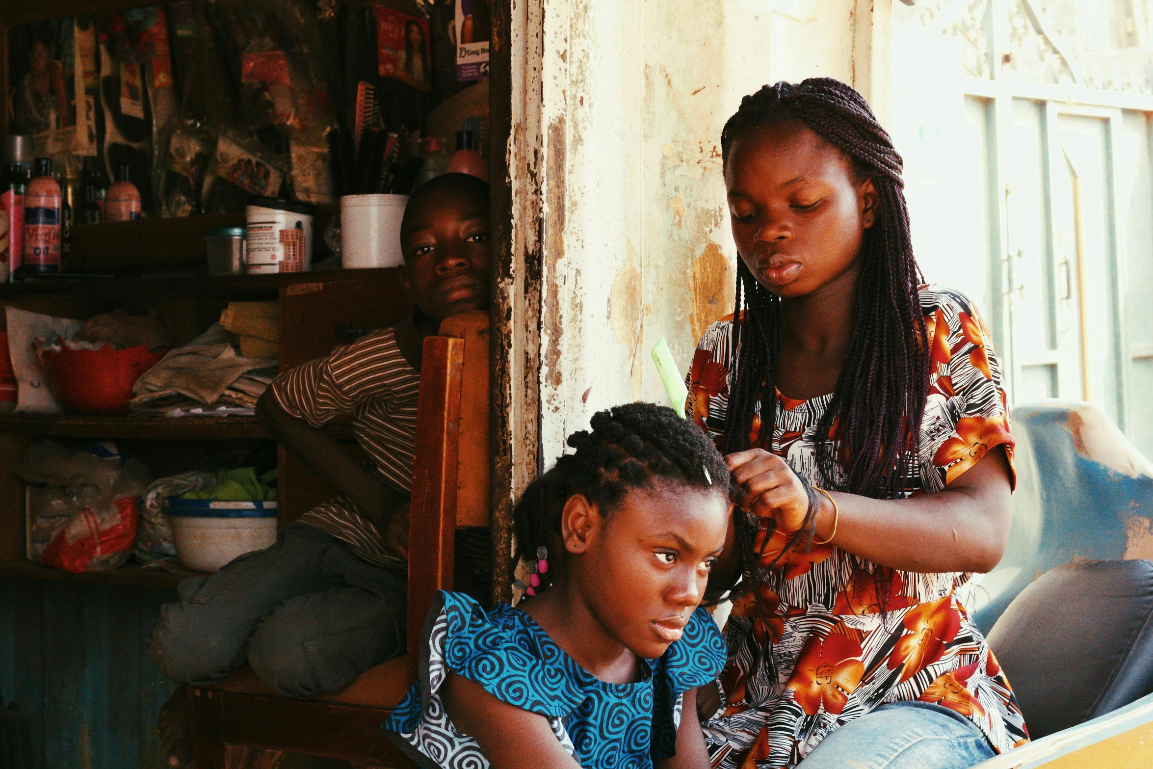 the woman is doing her hair and another is  it