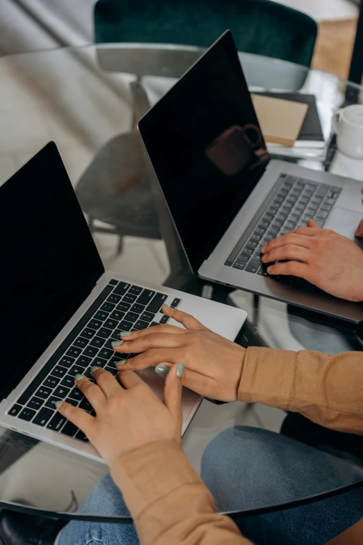 people with laptops sitting at tables in a coffee shop